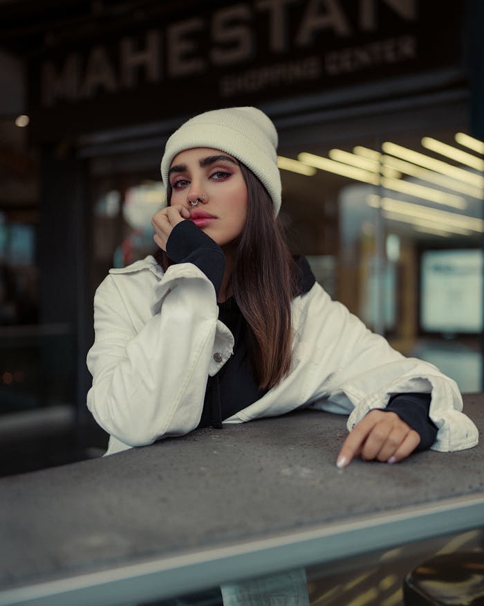 Young woman in stylish winter clothing posing in an urban setting.
